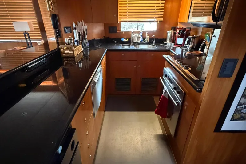 Slide: The Image of Luxurious 1999 Grand Alaskan Pilothouse kitchen with modern appliances and wooden cabinetry. - 10