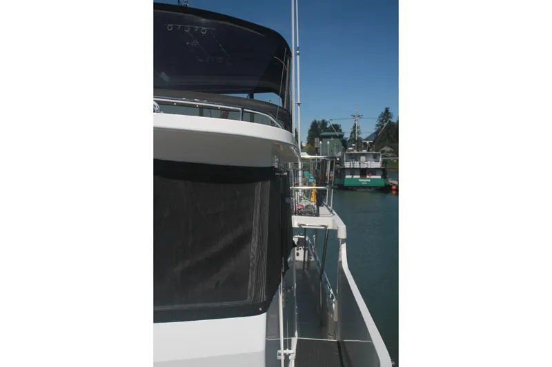 Slide: The Image of 1999 Grand Alaskan Pilothouse yacht docked, side view with clear blue sky. - 104