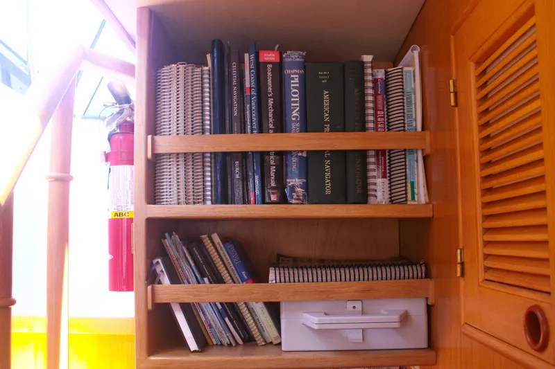 Slide: The Image of Bookshelf on 1999 Grand Alaskan Pilothouse with nautical books and fire extinguisher. - 105