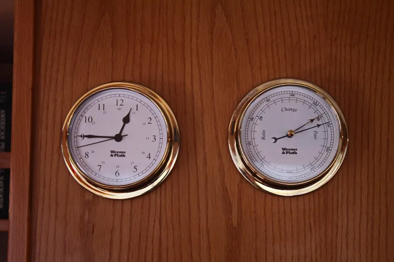 Slide: The Image of Gold-rimmed clock and barometer on Grand Alaskan Pilothouse, 1999 model, wooden background. - 108
