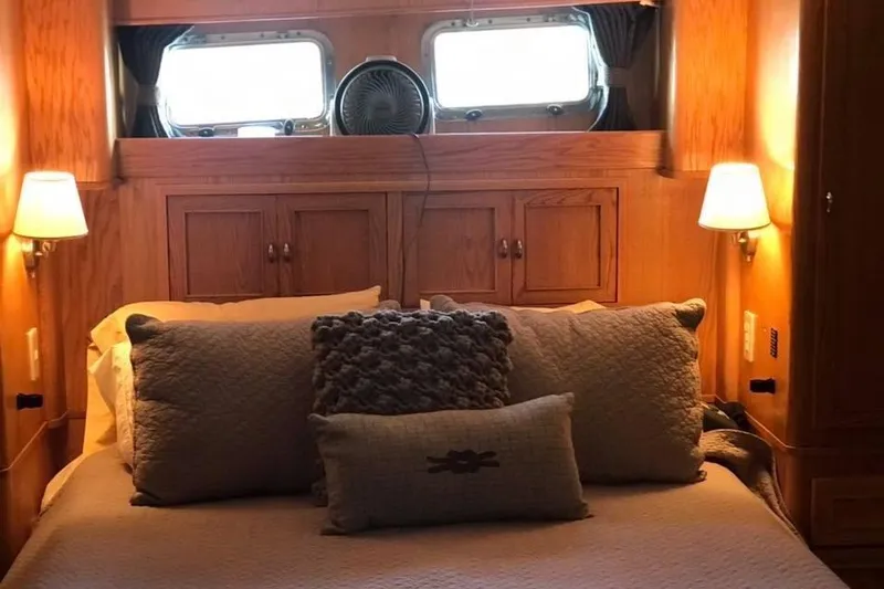 Slide: The Image of Cozy bedroom interior of 1999 Grand Alaskan Pilothouse yacht with wooden accents and soft lighting. - 11