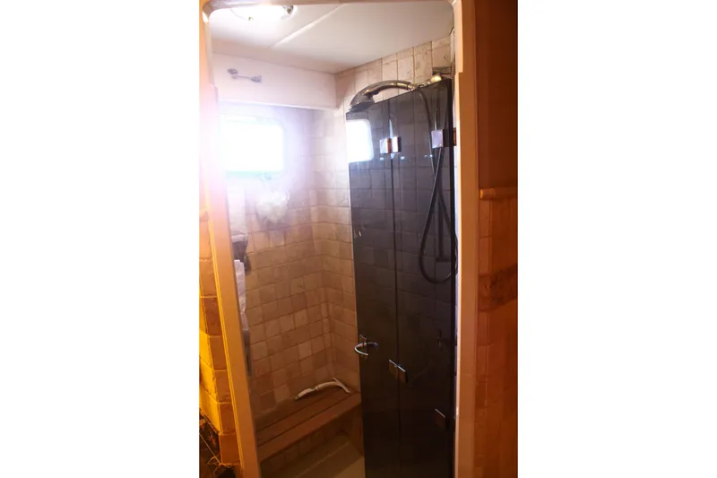 Slide: The Image of Shower area in 1999 Grand Alaskan Pilothouse, featuring tiled walls and glass door. - 113