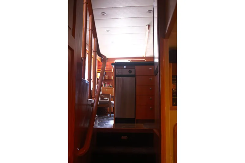 Slide: The Image of Interior view of 1999 Grand Alaskan Pilothouse yacht with wooden stairs and cabinetry. - 117