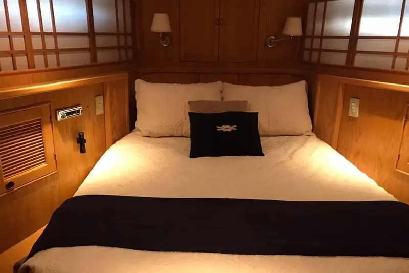 Slide: The Image of Cozy bedroom interior of 1999 Grand Alaskan Pilothouse yacht with wooden accents. - 12