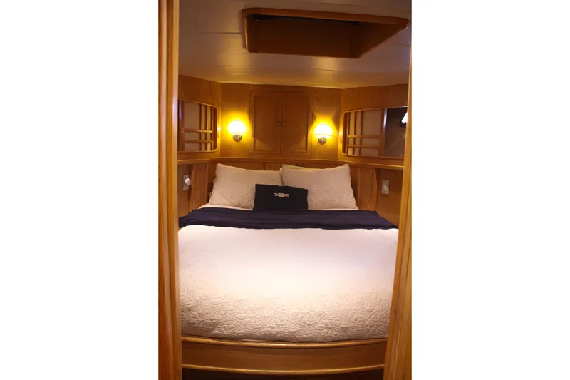 Slide: The Image of Cozy bedroom in 1999 Grand Alaskan Pilothouse yacht with warm wood paneling. - 121