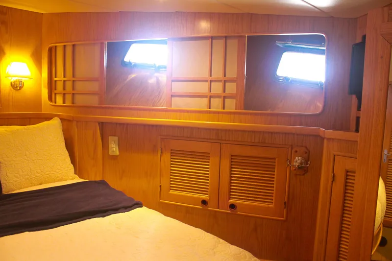 Slide: The Image of Cozy cabin interior of 1999 Grand Alaskan Pilothouse with wooden paneling and soft lighting. - 124