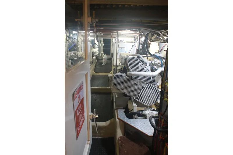 Slide: The Image of Engine room of 1999 Grand Alaskan Pilothouse yacht, showcasing machinery and equipment. - 129