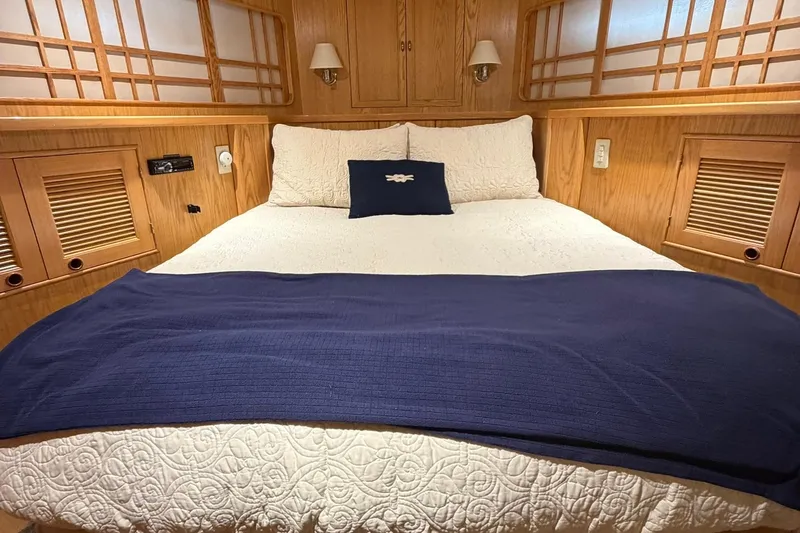 Slide: The Image of Luxurious 1999 Grand Alaskan Pilothouse cabin with cozy bed and elegant wood paneling. - 13