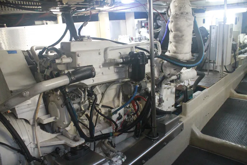 Slide: The Image of Engine room of a 1999 Grand Alaskan Pilothouse yacht, showcasing mechanical components. - 130