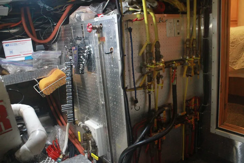 Slide: The Image of Engine room of a 1999 Grand Alaskan Pilothouse with pipes and maintenance tools. - 132