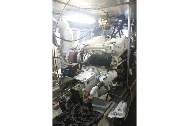 Slide: The Image of Engine room of 1999 Grand Alaskan Pilothouse yacht, showcasing complex machinery and piping. - 133