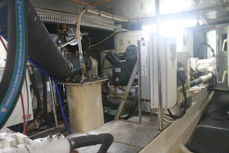 Slide: The Image of Engine room of a 1999 Grand Alaskan Pilothouse yacht, showcasing mechanical equipment and piping. - 136