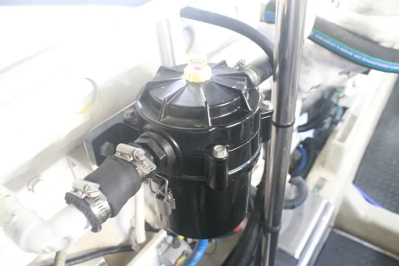 Slide: The Image of Engine component in a 1999 Grand Alaskan Pilothouse boat, featuring hoses and clamps. - 137