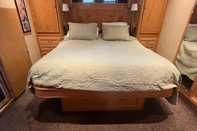 Slide: The Image of Luxurious bedroom interior of 1999 Grand Alaskan Pilothouse with elegant bedding and wooden cabinetry. - 14