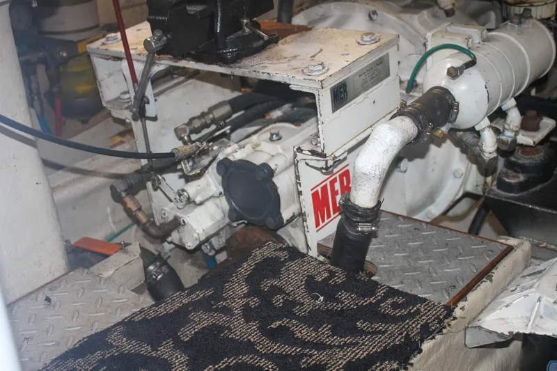 Slide: The Image of Engine room of a 1999 Grand Alaskan Pilothouse yacht, featuring mechanical components and piping. - 147