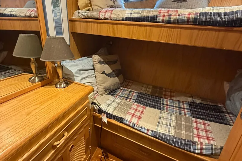 Slide: The Image of Cozy 1999 Grand Alaskan Pilothouse cabin with bunk beds and nautical-themed decor. - 15