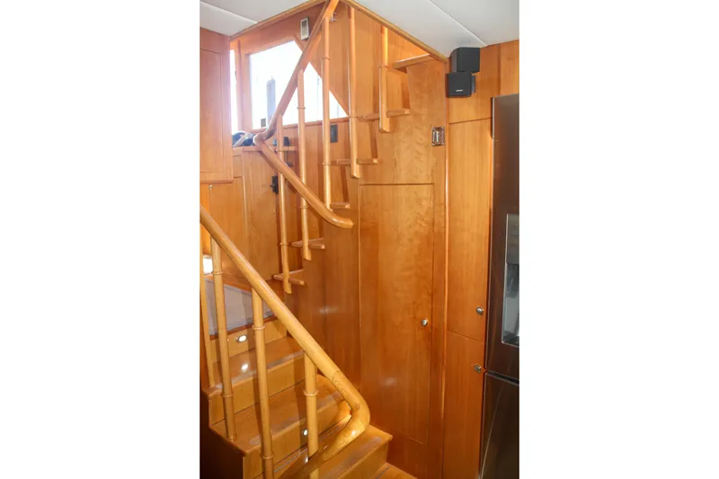 Slide: The Image of Wooden staircase inside a 1999 Grand Alaskan Pilothouse yacht, featuring elegant craftsmanship. - 152