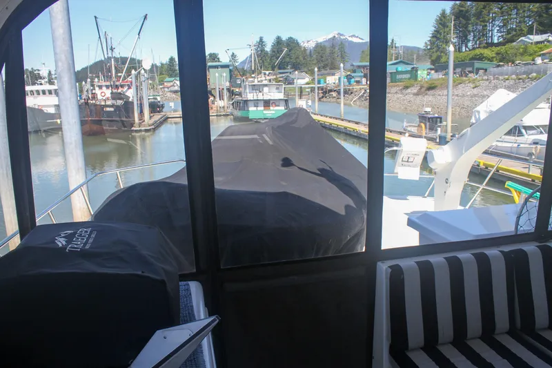 Slide: The Image of 1999 Grand Alaskan Pilothouse yacht docked in a scenic marina with covered equipment. - 153