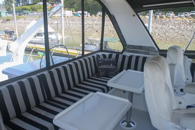 Slide: The Image of Interior of 1999 Grand Alaskan Pilothouse with striped seating and waterfront view. - 154