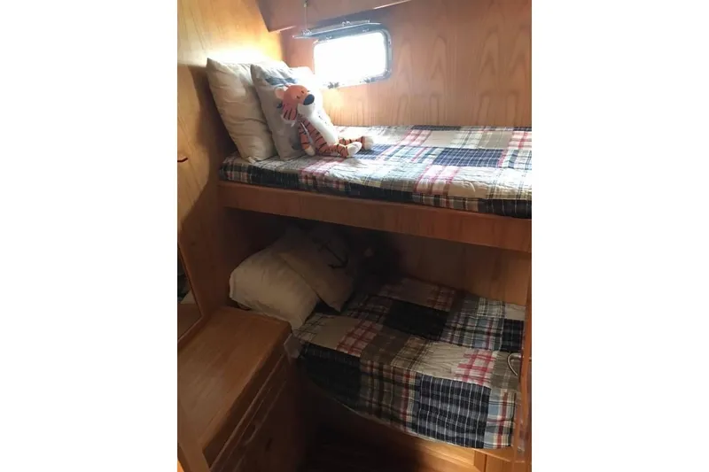 Slide: The Image of Bunk beds in 1999 Grand Alaskan Pilothouse cabin with plaid bedding and stuffed animal. - 16