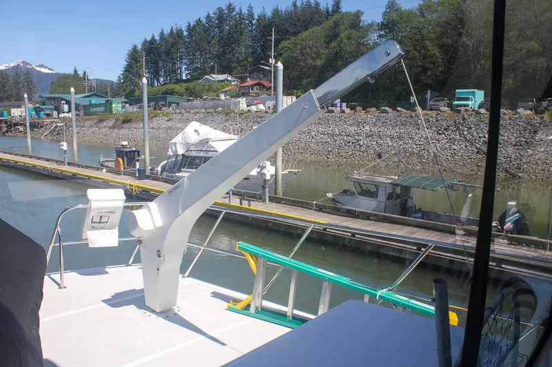 Slide: The Image of 1999 Grand Alaskan Pilothouse yacht docked at a marina with scenic forest backdrop. - 161