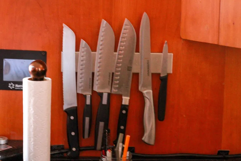 Slide: The Image of Magnetic knife holder with assorted knives on wooden wall, Grand Alaskan Pilothouse 1999. - 164