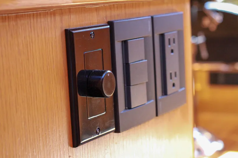 Slide: The Image of Dimmer switch and outlets on 1999 Grand Alaskan Pilothouse wooden interior. - 168