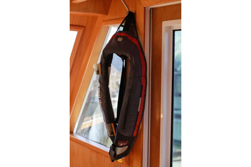 Slide: The Image of Life jacket hanging inside 1999 Grand Alaskan Pilothouse boat, near window. - 169