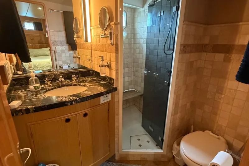 Slide: The Image of Luxurious bathroom in 1999 Grand Alaskan Pilothouse yacht with marble countertop and modern shower. - 17
