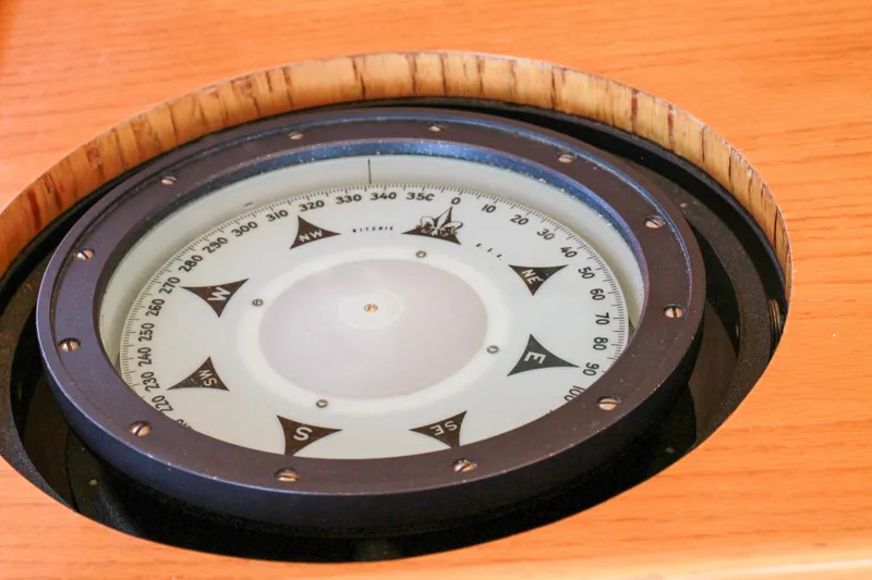 Slide: The Image of Compass on 1999 Grand Alaskan Pilothouse, showcasing navigation details on wooden surface. - 179