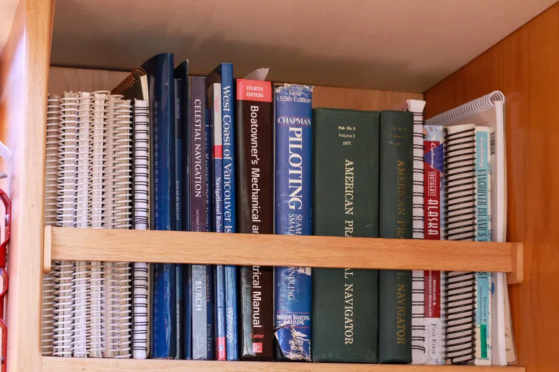Slide: The Image of Bookshelf with navigation and boating manuals on a Grand Alaskan Pilothouse, 1999 model. - 180