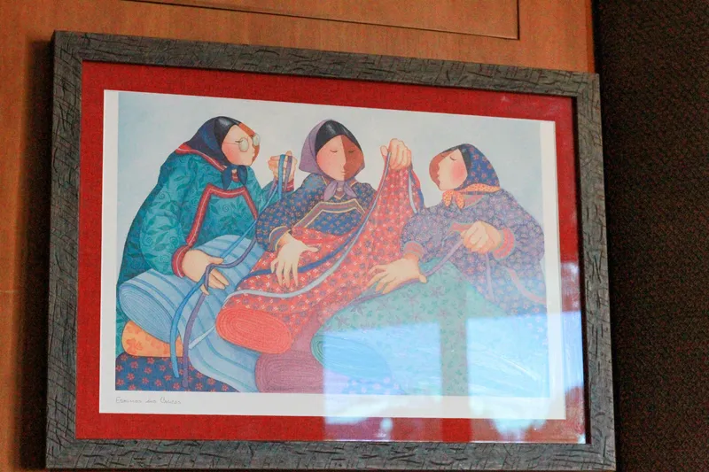 Slide: The Image of Framed artwork depicting three women knitting, displayed on a Grand Alaskan Pilothouse, 1999. - 188