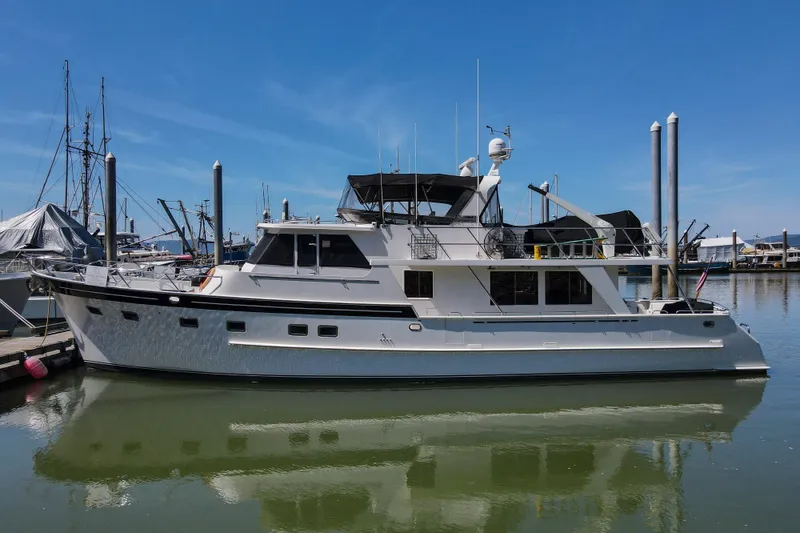 Slide: The Image of 1999 Grand Alaskan Pilothouse yacht cruising on calm waters under cloudy skies. - 189
