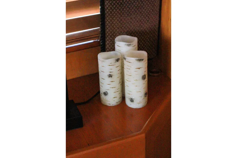 Slide: The Image of Birch-patterned candles on a wooden surface inside a 1999 Grand Alaskan Pilothouse. - 190