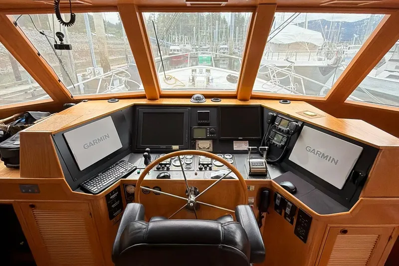 Slide: The Image of Pilothouse interior of 1999 Grand Alaskan, featuring Garmin navigation systems and steering wheel. - 2