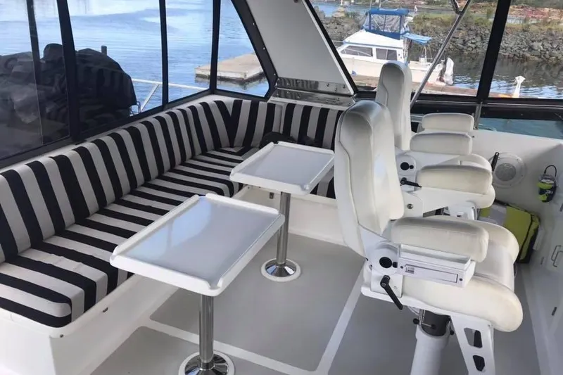 Slide: The Image of Interior of 1999 Grand Alaskan Pilothouse with striped seating and white captain chairs. - 22