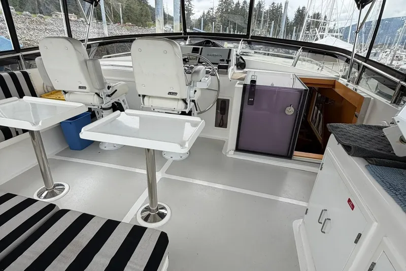 Slide: The Image of 1999 Grand Alaskan Pilothouse interior with helm, seating, and navigation equipment. - 23