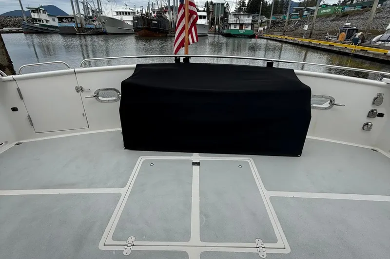Slide: The Image of 1999 Grand Alaskan Pilothouse deck with covered equipment, docked in a marina. - 26
