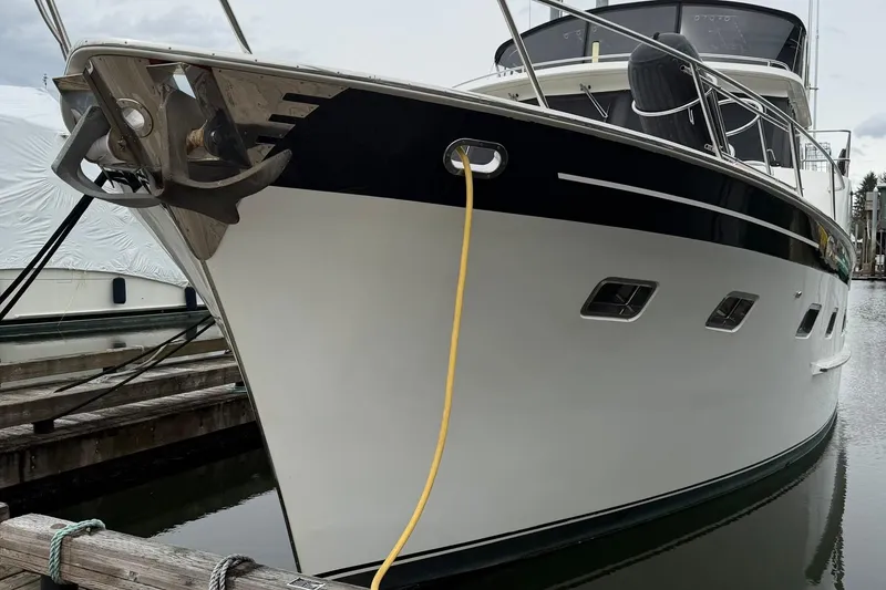Slide: The Image of 1999 Grand Alaskan Pilothouse yacht docked, showcasing sleek design and anchor detail. - 32