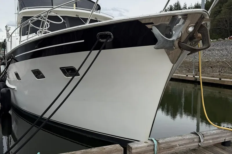 Slide: The Image of 1999 Grand Alaskan Pilothouse yacht docked, showcasing sleek design and sturdy anchor. - 33