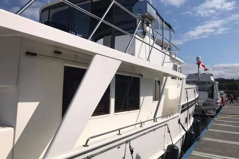Slide: The Image of 1999 Grand Alaskan Pilothouse yacht docked at marina under clear sky. - 34