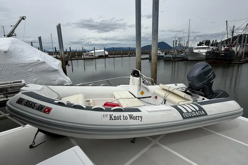 Slide: The Image of Novurania inflatable boat "Knot to Worry" docked, featuring Yamaha engine, near Grand Alaskan Pilothouse. - 35