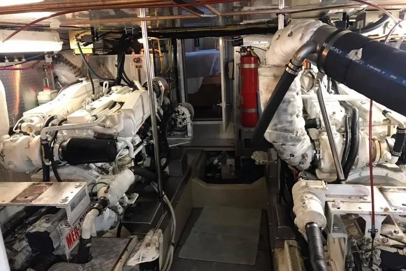Slide: The Image of Engine room of a 1999 Grand Alaskan Pilothouse yacht, featuring dual engines and equipment. - 36