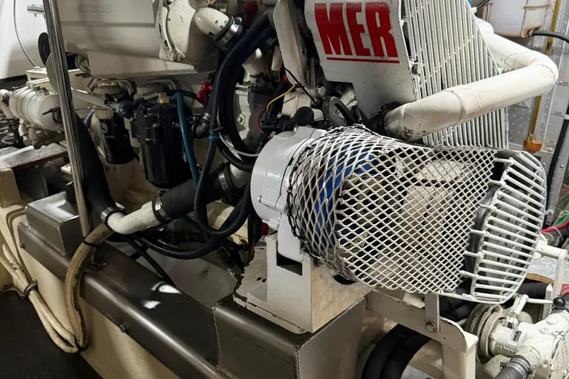 Slide: The Image of Engine room of 1999 Grand Alaskan Pilothouse yacht, showcasing mechanical components and wiring. - 37