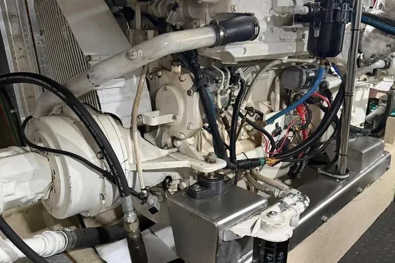 Slide: The Image of Engine room of a 1999 Grand Alaskan Pilothouse, showcasing mechanical components and wiring. - 38