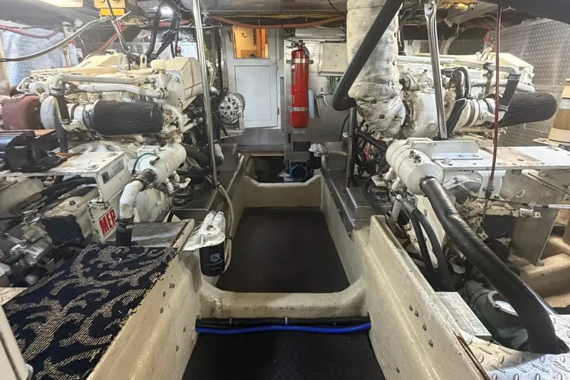 Slide: The Image of Engine room of a 1999 Grand Alaskan Pilothouse yacht, showcasing dual engines and equipment. - 43