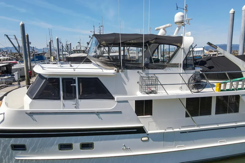Slide: The Image of 1999 Grand Alaskan Pilothouse yacht docked at marina under clear blue sky. - 76
