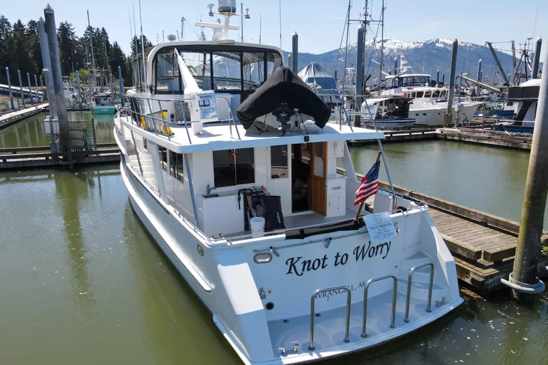 Slide: The Image of 1999 Grand Alaskan Pilothouse yacht docked in marina, displaying American flag. - 78