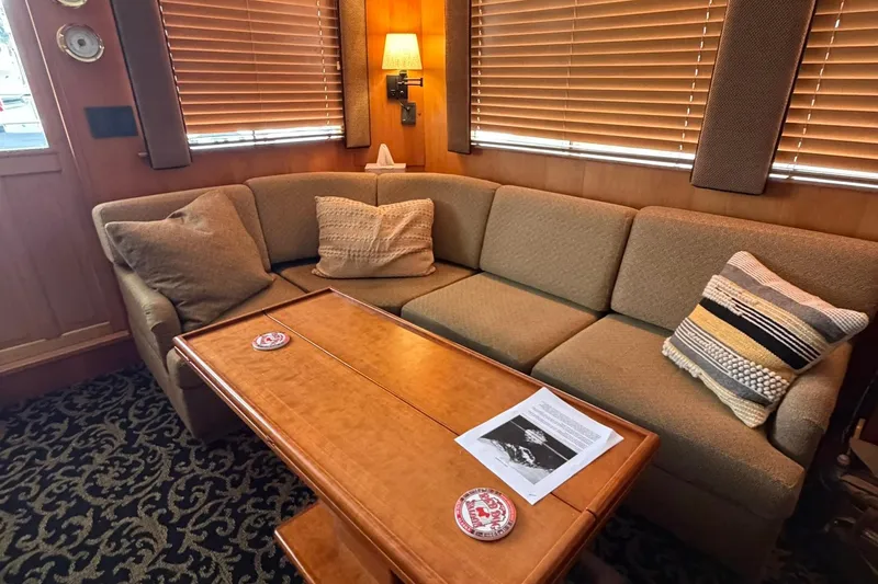 Slide: The Image of Cozy 1999 Grand Alaskan Pilothouse interior with plush sofa and wooden table. - 8