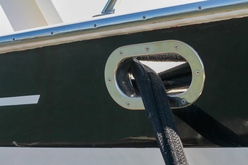 Slide: The Image of Close-up of a 1999 Grand Alaskan Pilothouse boat's mooring line through a metal fairlead. - 92